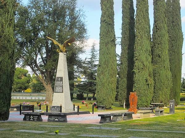 Armenian Genocide memorial with a golden eagle among cypress trees at Ararat Armenian Cemetery