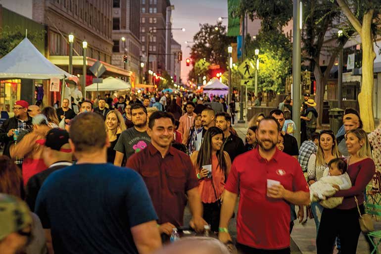 A crowd of families and friends at an outdoor community event in Fresno
